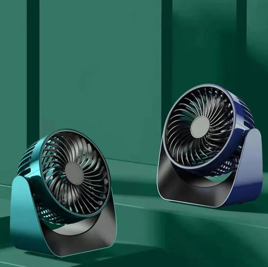 Compact desktop fan with 360 degree rotating head on a workspace desk