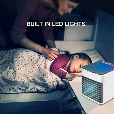 Portable air conditioner fan with LED lamp and humidifier on a home office desk.