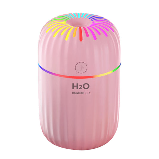 Compact 3 in 1 air humidifier emitting fine mist on a wooden desk